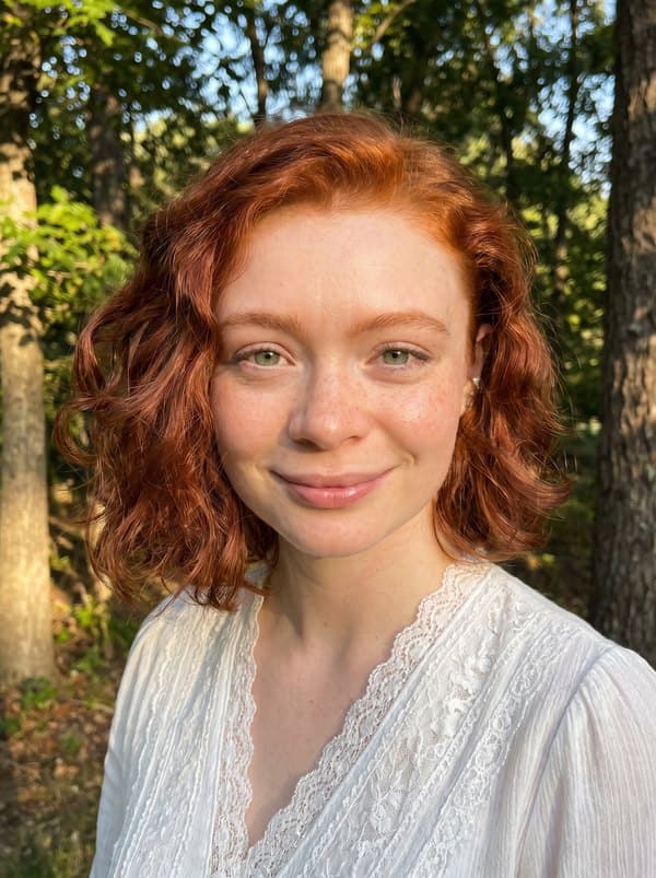 Sarah Lee, smiling outdoors in evening sunlight