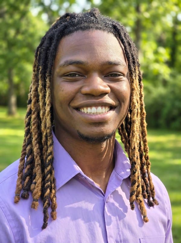 William Sessions, smiling outdoors among green trees